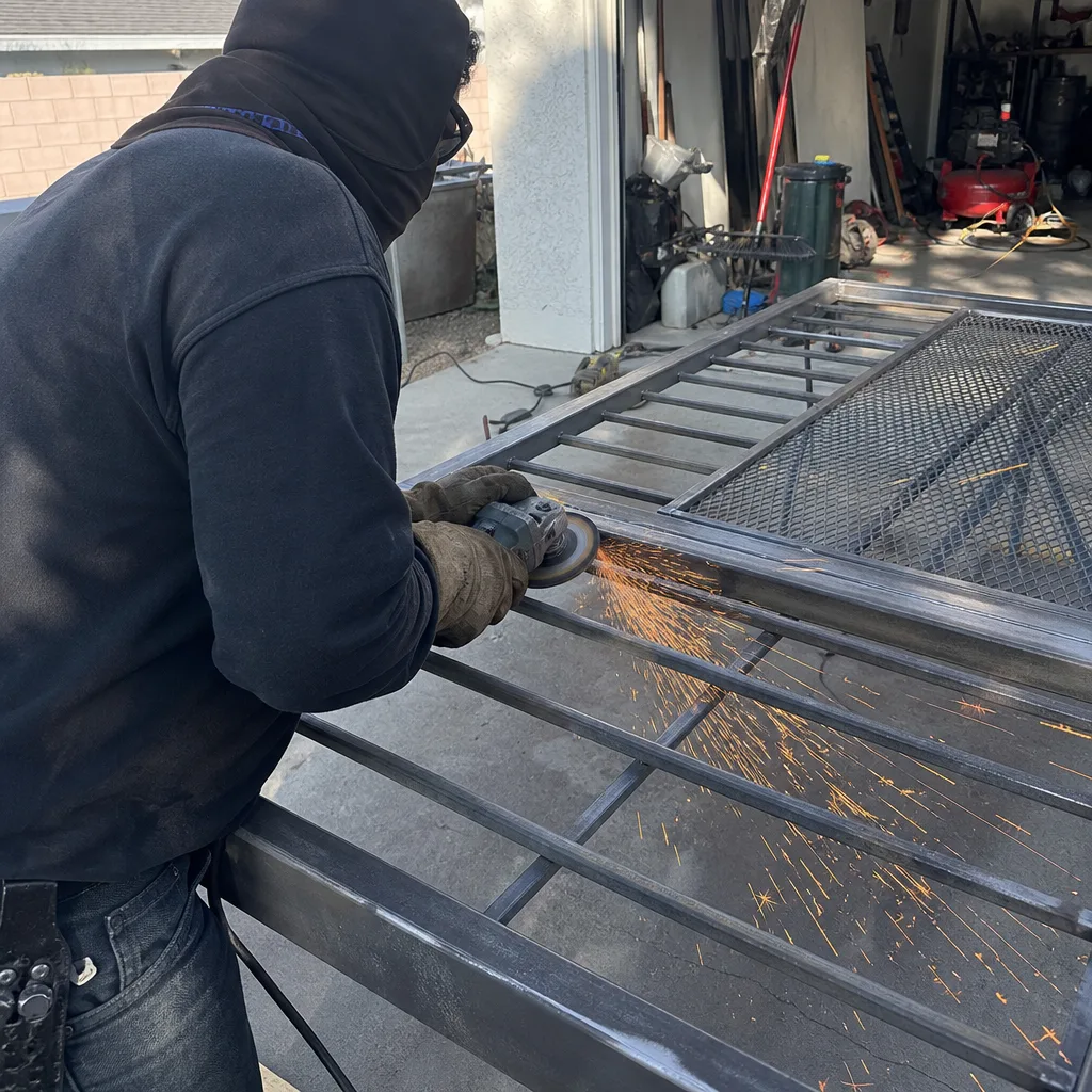 Metal worker using angle grinder for custom gate welding repair in Fontana, CA